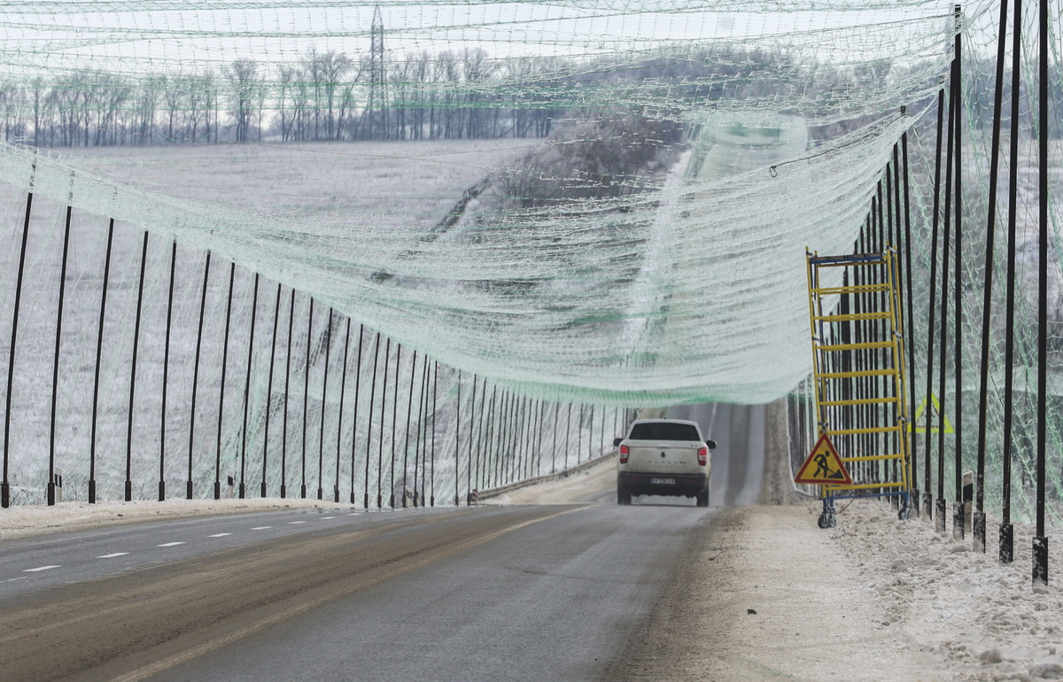 우크라이나 하르키우 지역의 한 도로에 차량이 지나가고 있다. 도로 주변에 설치된 그물은 러시아 자폭드론의 공격으로부터 차량과 인력을 보호하기 위해 설치된 그물망이다. EPA 연합뉴스