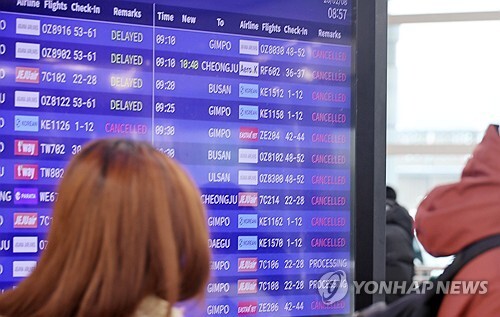 8일 제주국제공항에 많은 눈이 내려 제설작업으로 공항 운영이 오전 한때 중단된 가운데 제주공항 운항 안내판에 결항과 지연 편들이 안내되고 있다.