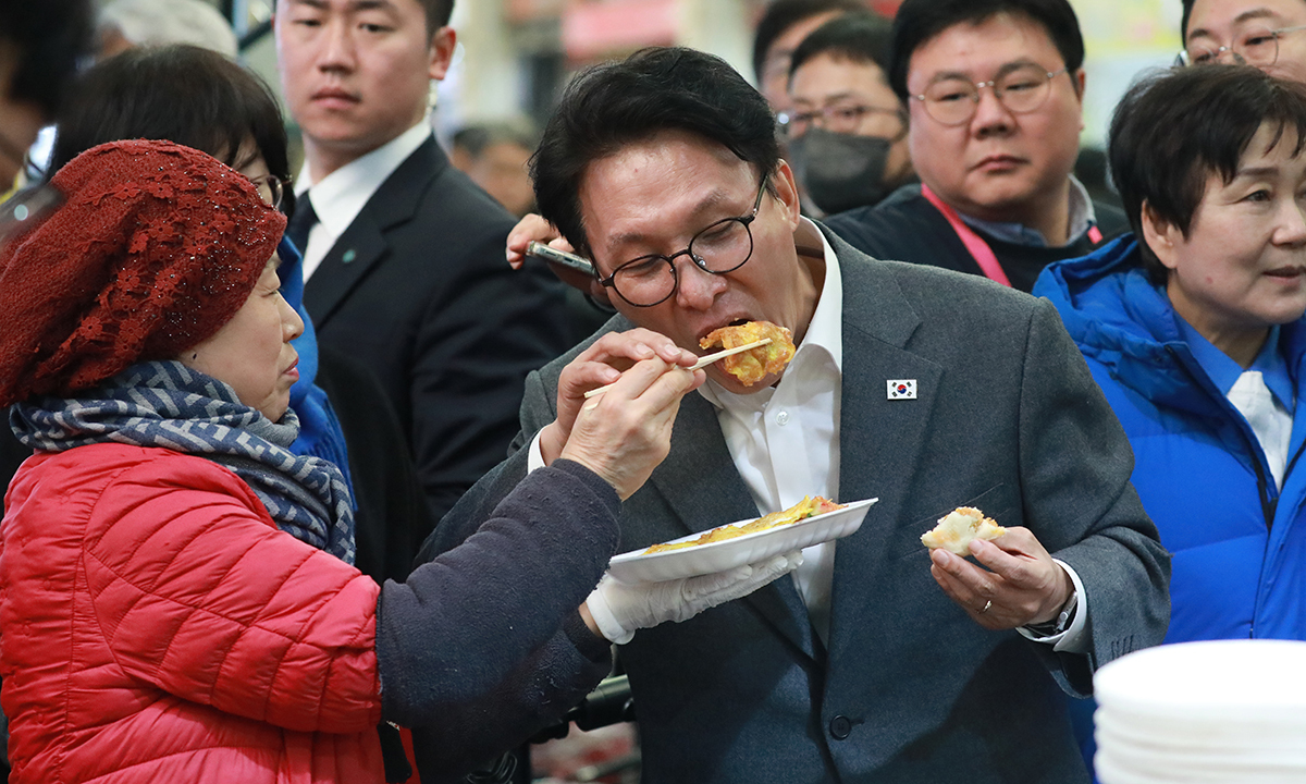 김민석 국무총리가 12일 설 연휴를 앞두고 충북 청주 육거리종합시장을 찾아 음식을 먹으며 상인들과 소통하고 있다. 뉴시스