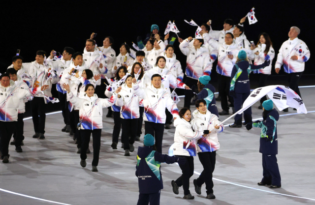 6일(현지시간) 이탈리아 밀라노 산시로 스타디움에서 열린 2026 밀라노·코르티나담페초 동계올림픽 개회식. 대한민국 기수인 피겨 차준환과 스피드스케이팅 박지우가 태극기를 들고 입장하고 있다. 연합뉴스