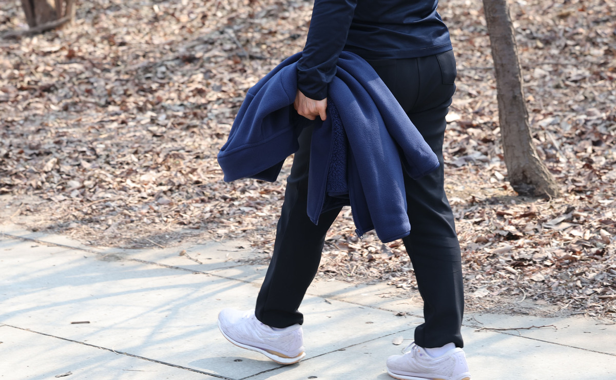 산책하는 한 시민. 외투를 손에 들었다.