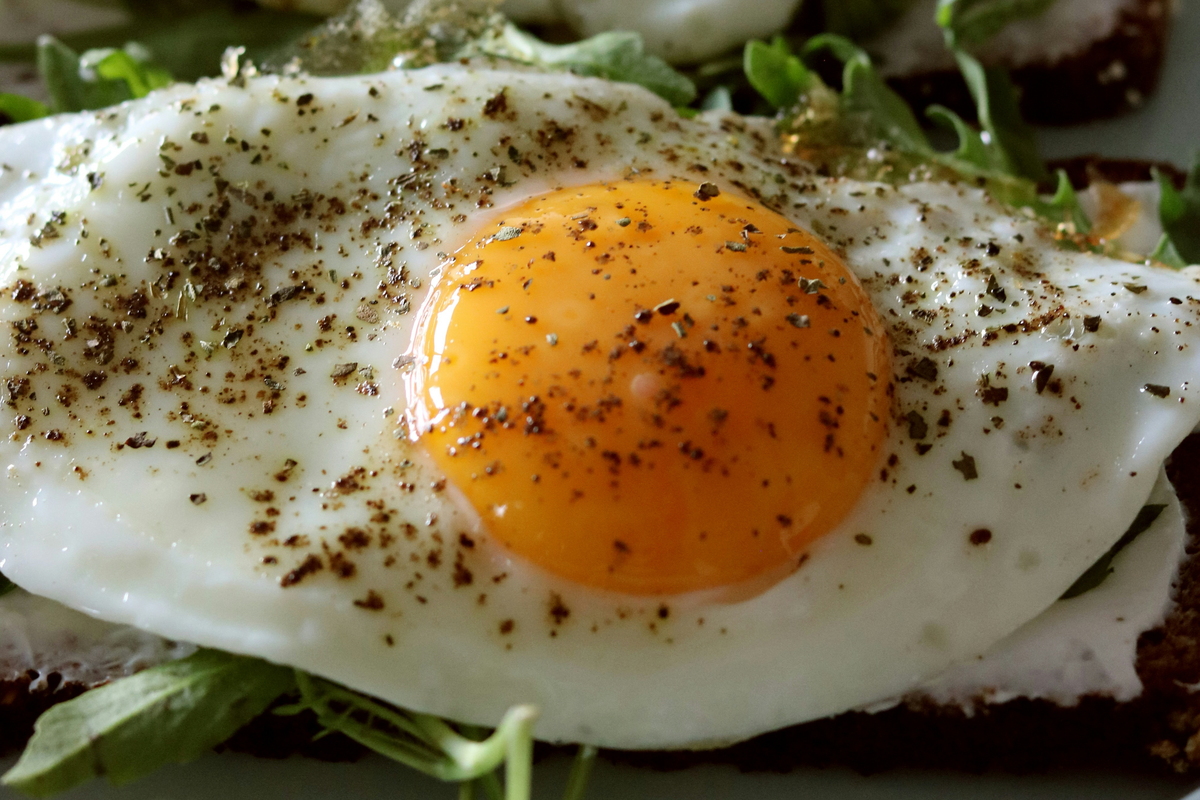 프라이팬 위에서 익어가는 달걀 위로 엑스트라버진 올리브유가 둘러지고 있다. 건강식으로 알려진 조합이지만, 올리브유 2큰술을 더하면 한 끼 열량은 380~400kcal 수준까지 올라간다. unsplash