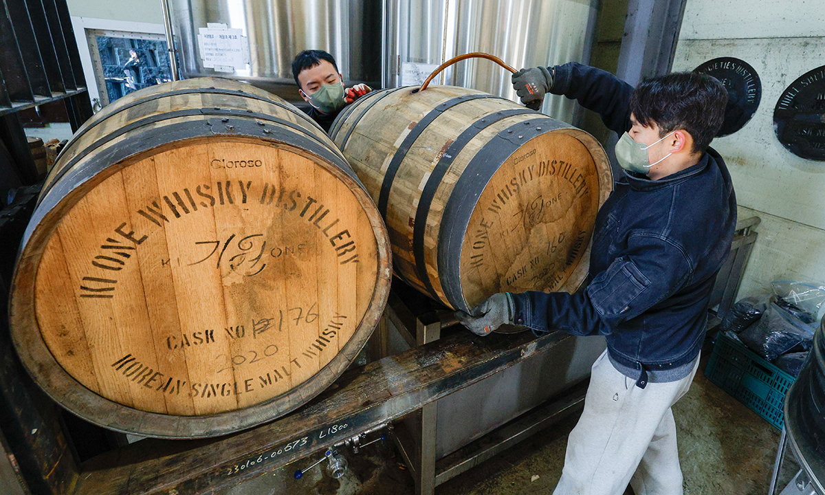 직원들이 숙성이 된 위스키 오크통을 비워내고 있다.