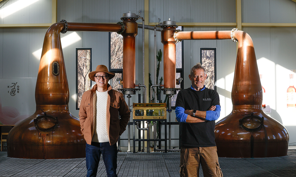 기원 도정한 대표, 앤드루 샌드 마스터 디스틸러가 경기 남양주시 화도읍 기원 위스키 증류소 증류기 앞에서 포즈를 취하고 있다.