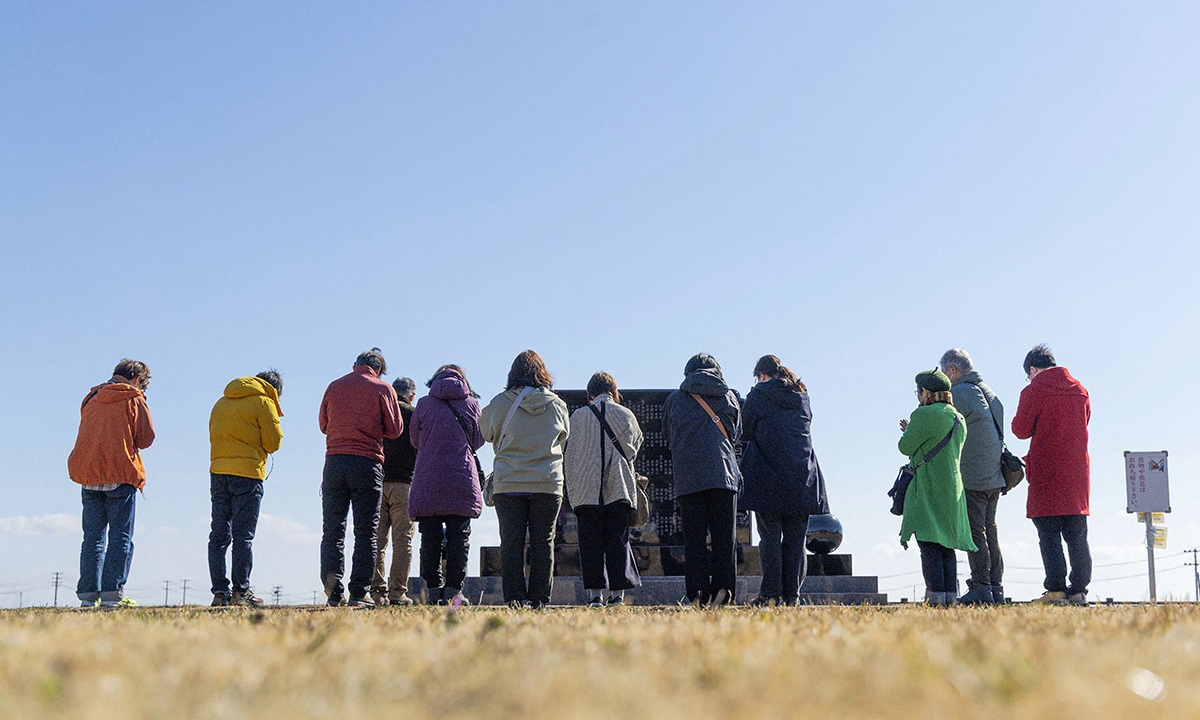 2011년 동일본대지진 15주년인 11일 일본 후쿠시마현 나미에마을 주민들이 희생자 추모비 앞에서 기도하고 있다. 후쿠시마 제1원전에서 약 8㎞ 떨어진 나미에마을은 당시 거대 쓰나미로 주민 1만9000여명이 죽거나 실종됐고, 방사능 유출로 마을 전체가 피난길에 올라야 했다. 나미에=AFP연합뉴스