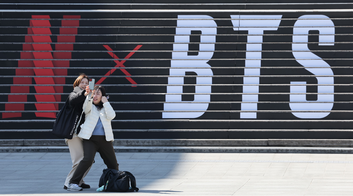 방탄소년단의 컴백 라이브 공연을 일주일여 앞둔 13일 서울 종로구 세종문화회관 계단에 마련된 방탄소년단 공연 홍보물 앞에서 외국인 관광객들이 기념촬영을 하고 있다.