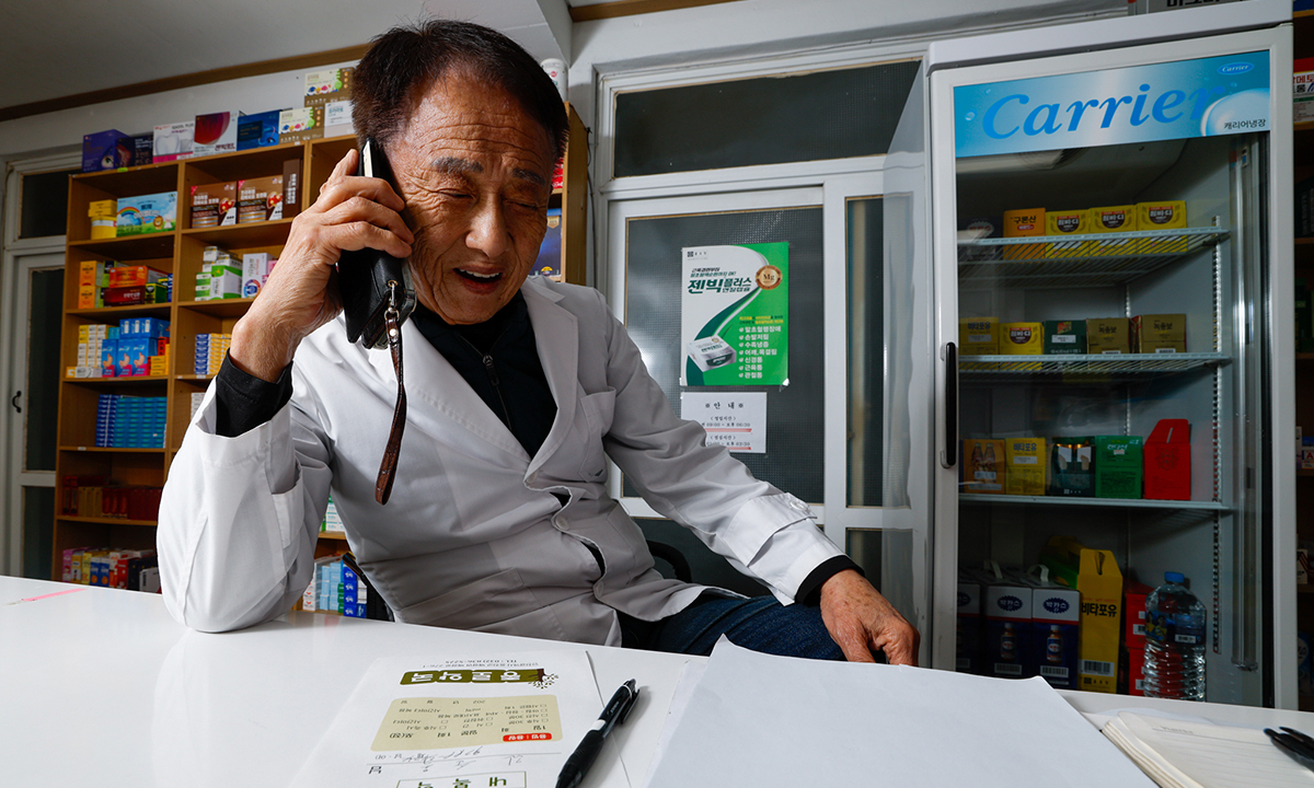 최영덕 약사가 11일 인천 옹진군 백령도 종로약국에서 한 주민과 전화 통화를 나누며 약을 준비하고 있다.