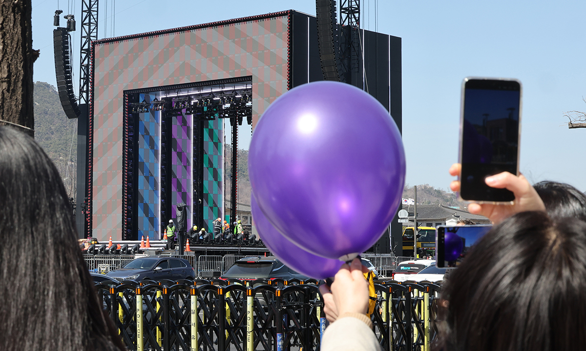 그룹 방탄소년단(BTS)의 광화문 공연을 앞둔 19일 서울 종로구 광화문광장 공연장 앞에서 시민들이 무대 설치작업을 보고 있다. 연합뉴스