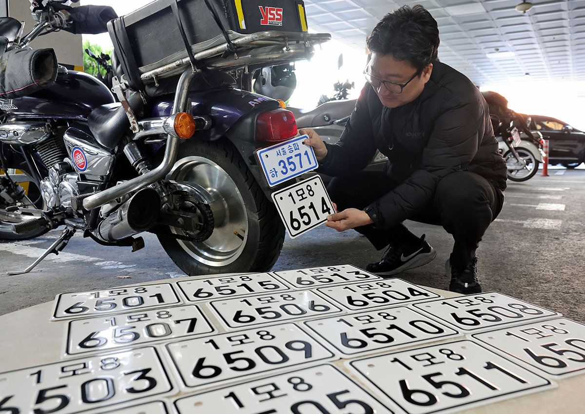 “보기 더 쉬워졌네” 이륜자동차 전국 번호판 제도 시행을 하루 앞둔 19일 서울 송파구청에서 관계자가 새 이륜차 번호판과 기존 번호판을 비교해 보이고 있다. 새 번호판은 크기와 글자 색상, 반사 성능이 개선돼 주·야간 식별성이 기존 번호판보다 좋아졌다.&nbsp;이재문 기자