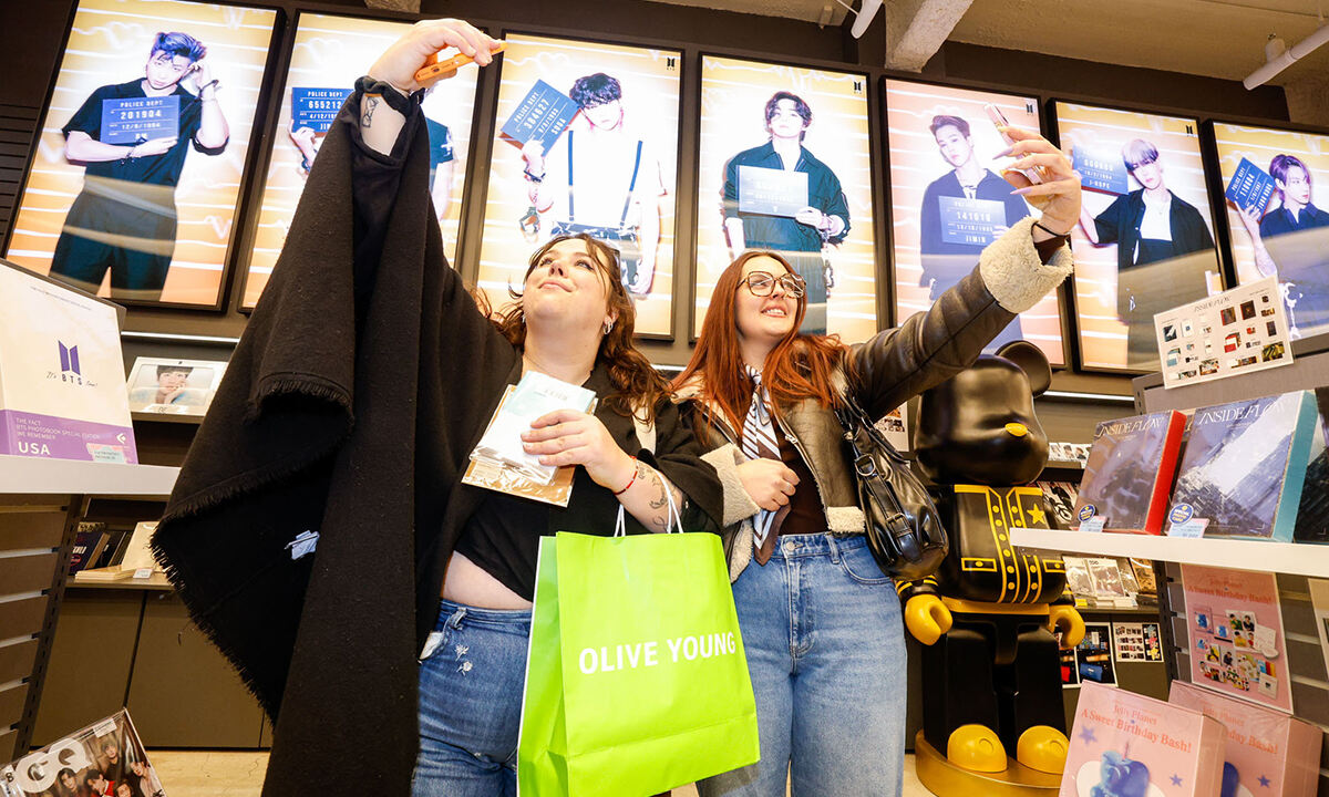 방탄소년단(BTS) 컴백 공연을 앞둔 20일 서울 중구 명동 K팝 특화 매장에서 프랑스인 ‘아미(BTS팬)’가 K팝 굿즈를 배경으로 기념사진을 찍고 있다. 유희태 기자