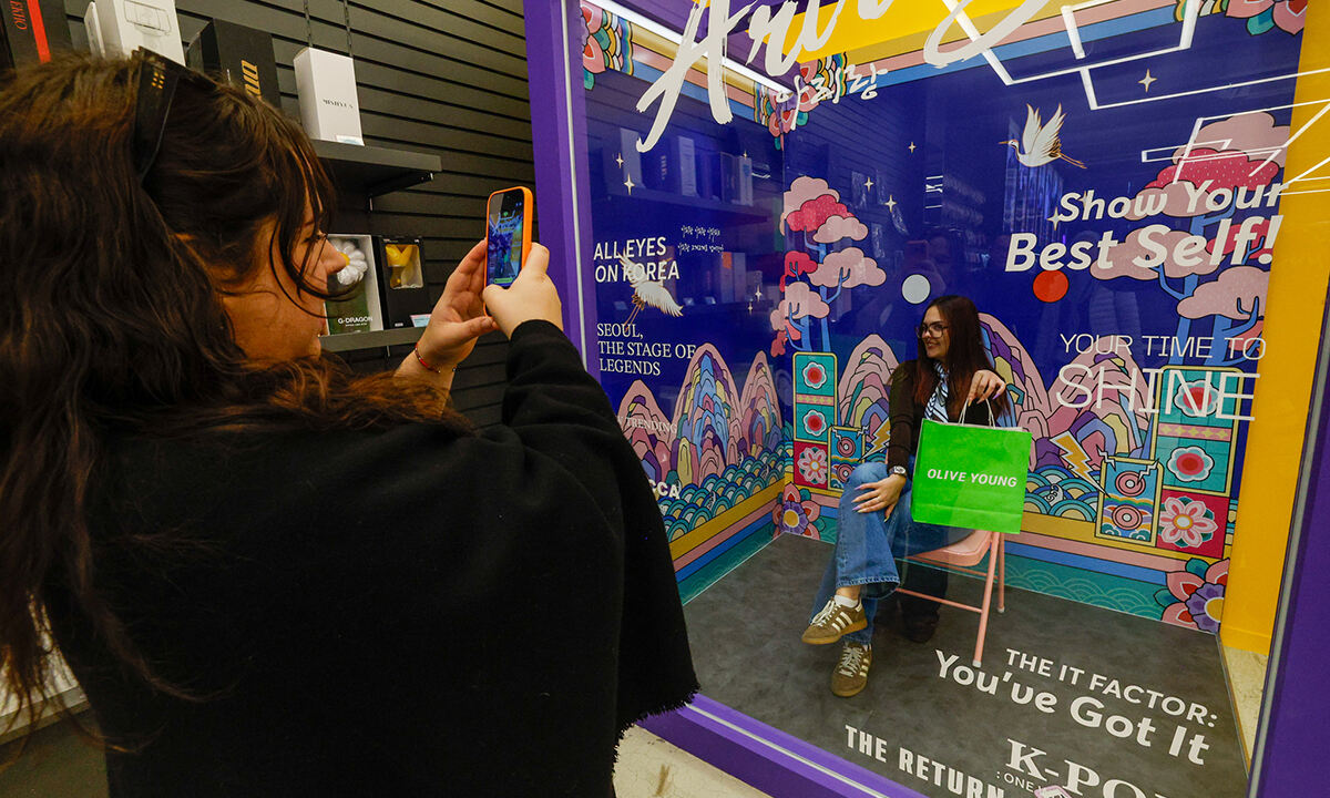 방탄소년단(BTS) 컴백 공연을 앞둔 19일 서울 중구 명동 K팝 특화 매장에서 프랑스인 ‘아미(BTS팬)’가 K팝 굿즈를 배경으로 기념사진을 찍고 있다. 유희태 기자