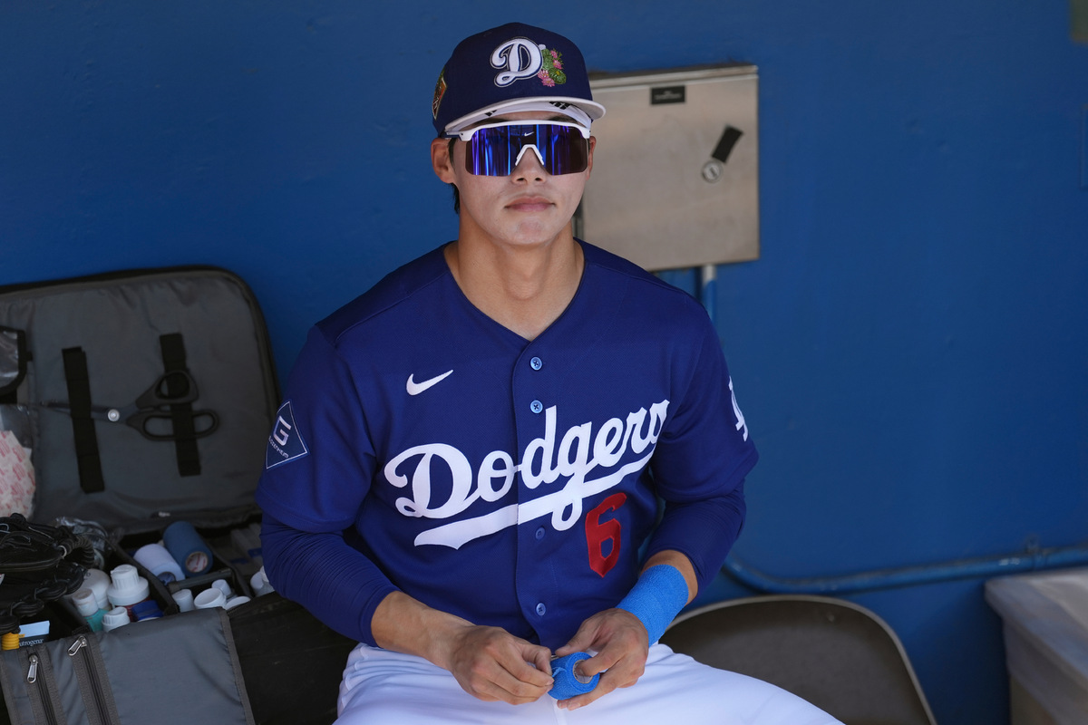 Los Angeles Dodgers' Hyeseong Kim, of South Korea, pauses in the dugout prior to a spring training baseball game against the Athletics, Saturday, March 21, 2026, in Phoenix. (AP Photo/Ross D. Franklin)