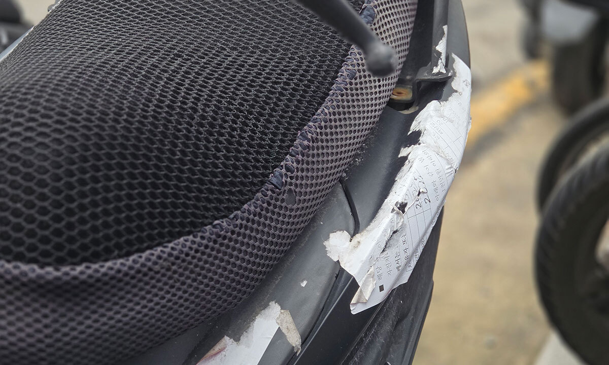 전기이륜차 의자 시트 아래 무단 방치 경고장이 붙어있다.