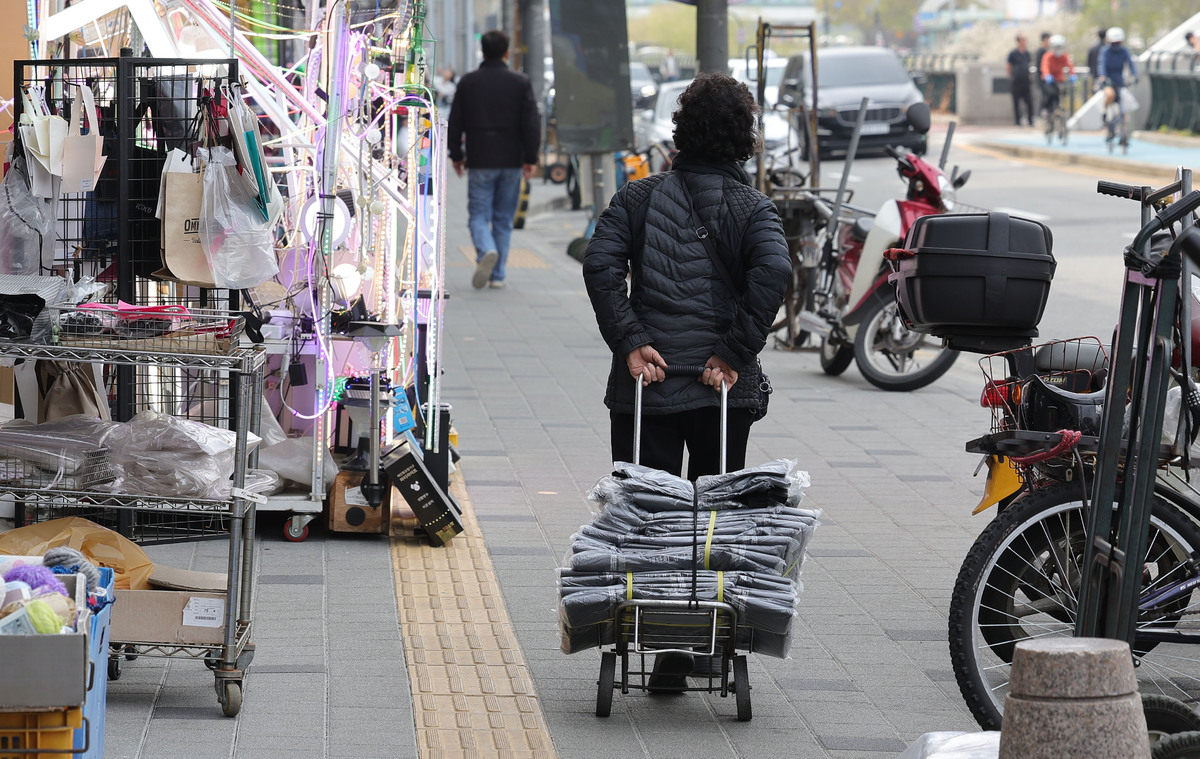 3일 서울 중구 방산시장에서 한 상인이 비닐봉지를 사가고 있다.