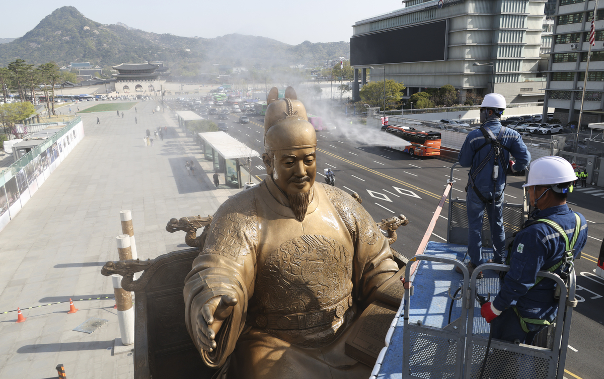13일 서울 광화문광장에서 서울시 관계자들이 세종대왕 동상을 세척하고 있다. 남정탁 기자