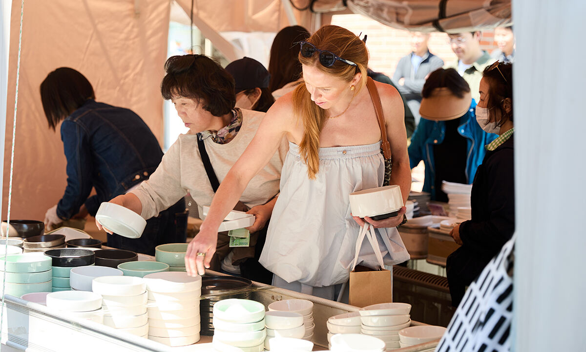 지난해 이천도자기축제 행사장을 방문한 외국 여성(오른쪽)이 구매할 그릇을 고르고 있다.