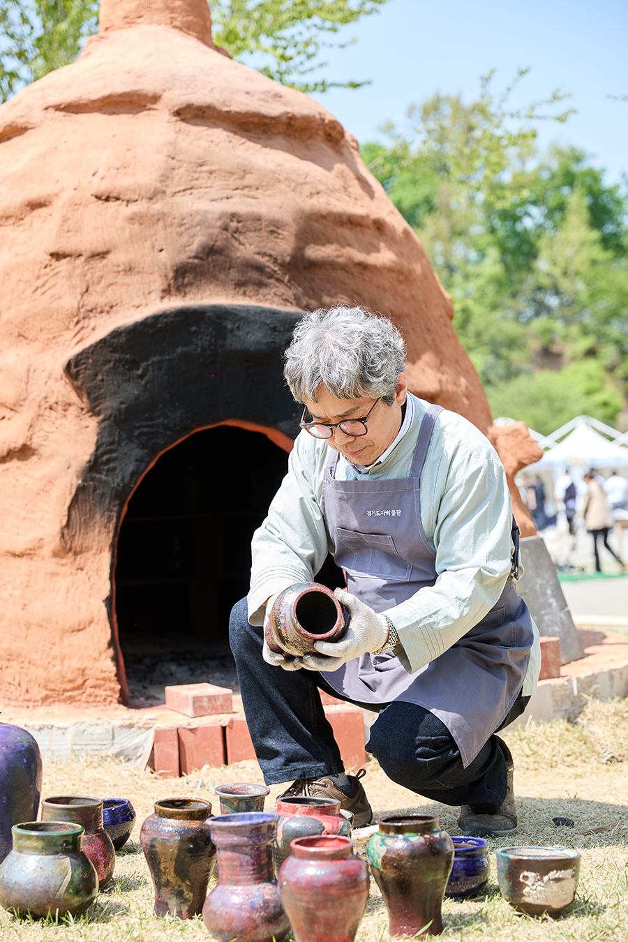 이천시의 한 도예촌에서 도자예술가가 가마에서 갓 구워낸 작품들을 살펴보고 있다.
