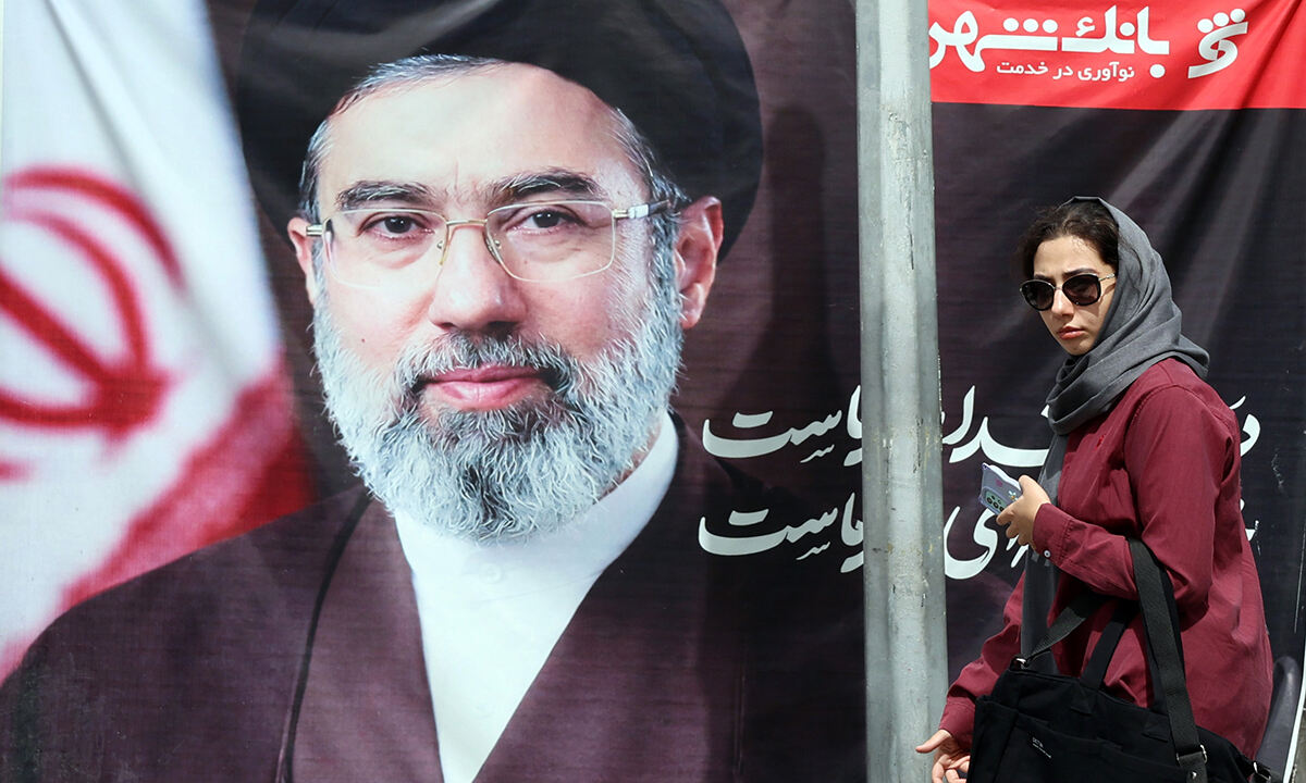 이란 테헤란의 거리에서 한 여성이 이란 최고지도자 모즈타바 하메네이의 사진 앞을 지나가고 있다. EPA연합뉴스