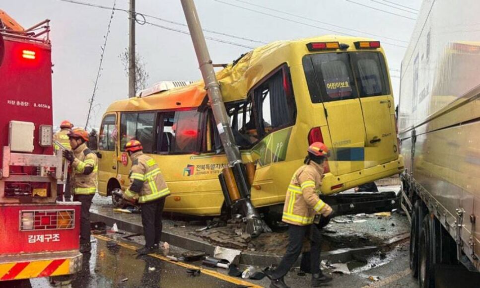 지난해 12월 23일 전북 김제시 백산면 상정리 지평선산단로 돌제교차로에서 초등학교 스쿨버스가 화물 윙바디 트럭과 충돌한 뒤 안전지대에 세워진 신호등과 추돌하는 사고가 나자 119 구조대원들이 분주하게 움직이고 있다. 전북도소방본부 제공