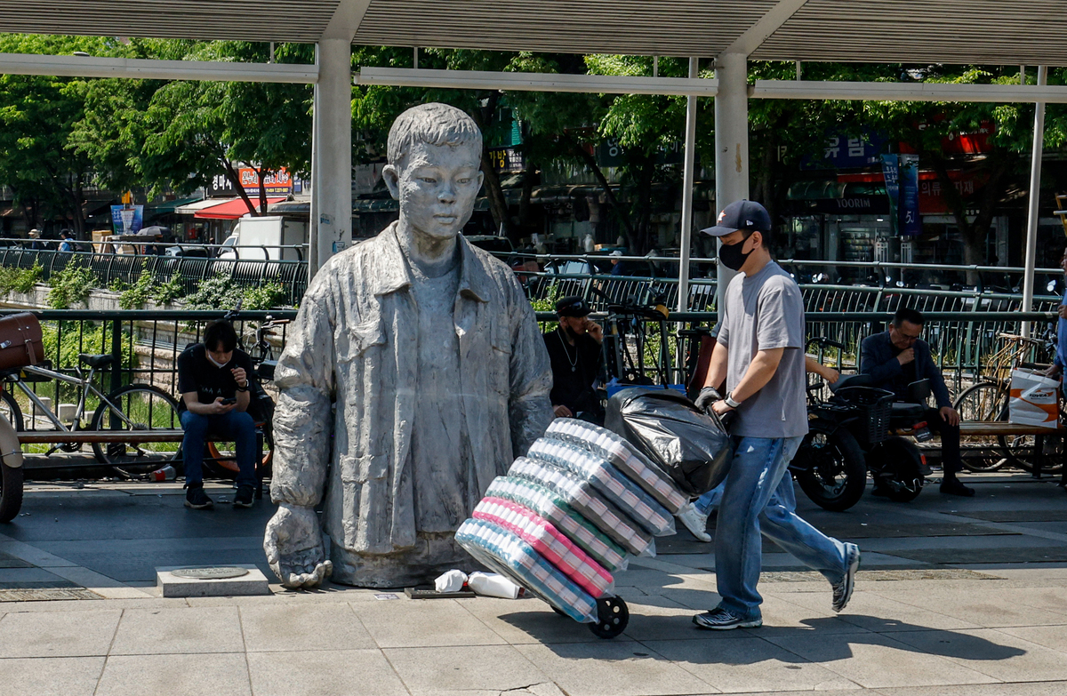 노동절을 하루 앞둔 30일 서울 종로구 청계천로 전태일 동상 앞을 시민들이 지나고 있다.