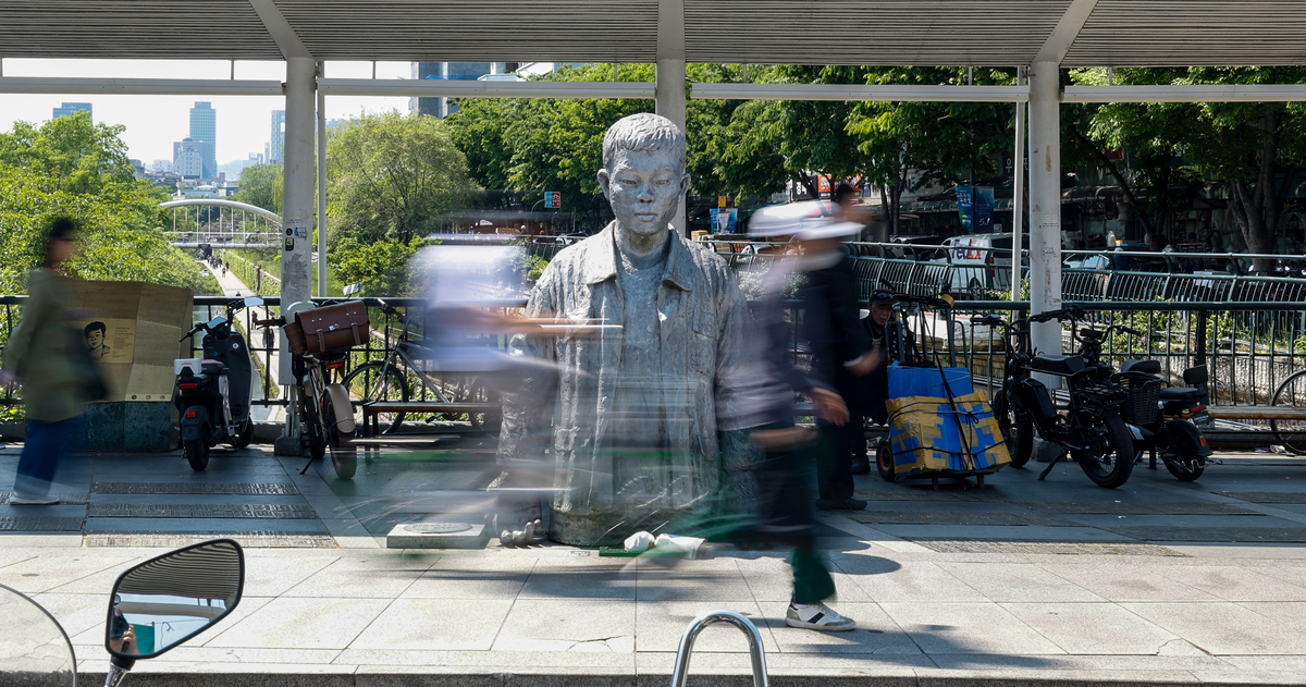 노동절을 하루 앞둔 30일 서울 종로구 청계천로 전태일 동상 앞을 시민들이 지나고 있다.