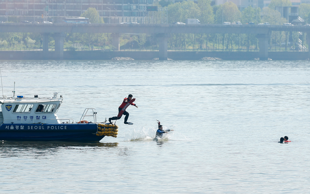 30일 서울 한강버스 여의도선착장 인근에서 열린 한강 복합 수난사고 대비 수상·육상 구조·구호 종합훈련에서 구조대원들이 승객들을 구조하기 위해 물 속에 뛰어들고 있다.