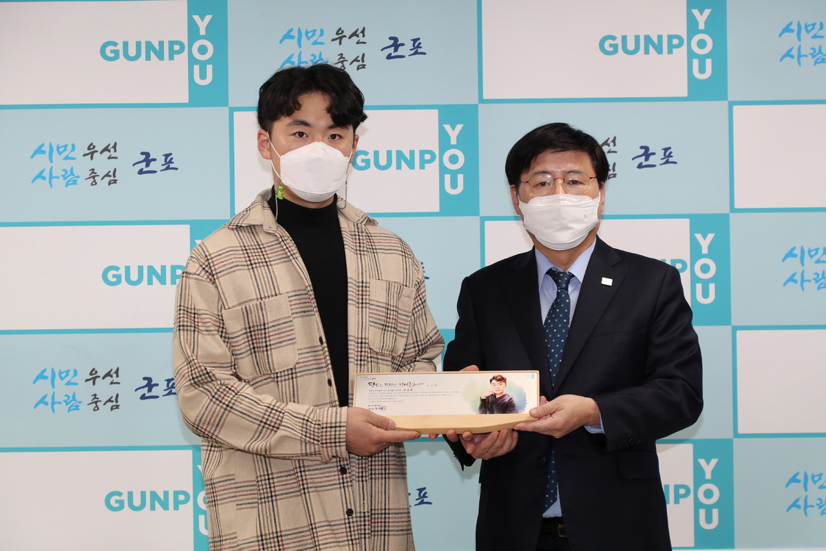 화재 현장에서 주민을 구한 사다리차 의인 한상훈 대표가 한대희 당시 군포 시장(오른쪽)에게 감사패를 수여받고 있다. 군포시 제공