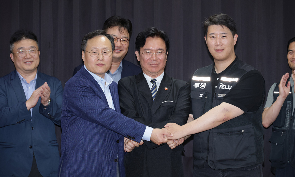 지난 20일 경기도 수원시 장안구 경기고용노동청에서 열린 삼성전자 임금협상을 마친 후 여명구 삼성전자 DS(디바이스솔루션·반도체 사업 담당) 피플팀장과 김영훈 고용노동부 장관, 최승호 삼성그룹 초기업노동조합 삼성전자지부 위원장이 잠정 합의한에 서명한 후 손을 맞잡고 있다. 공동취재사진