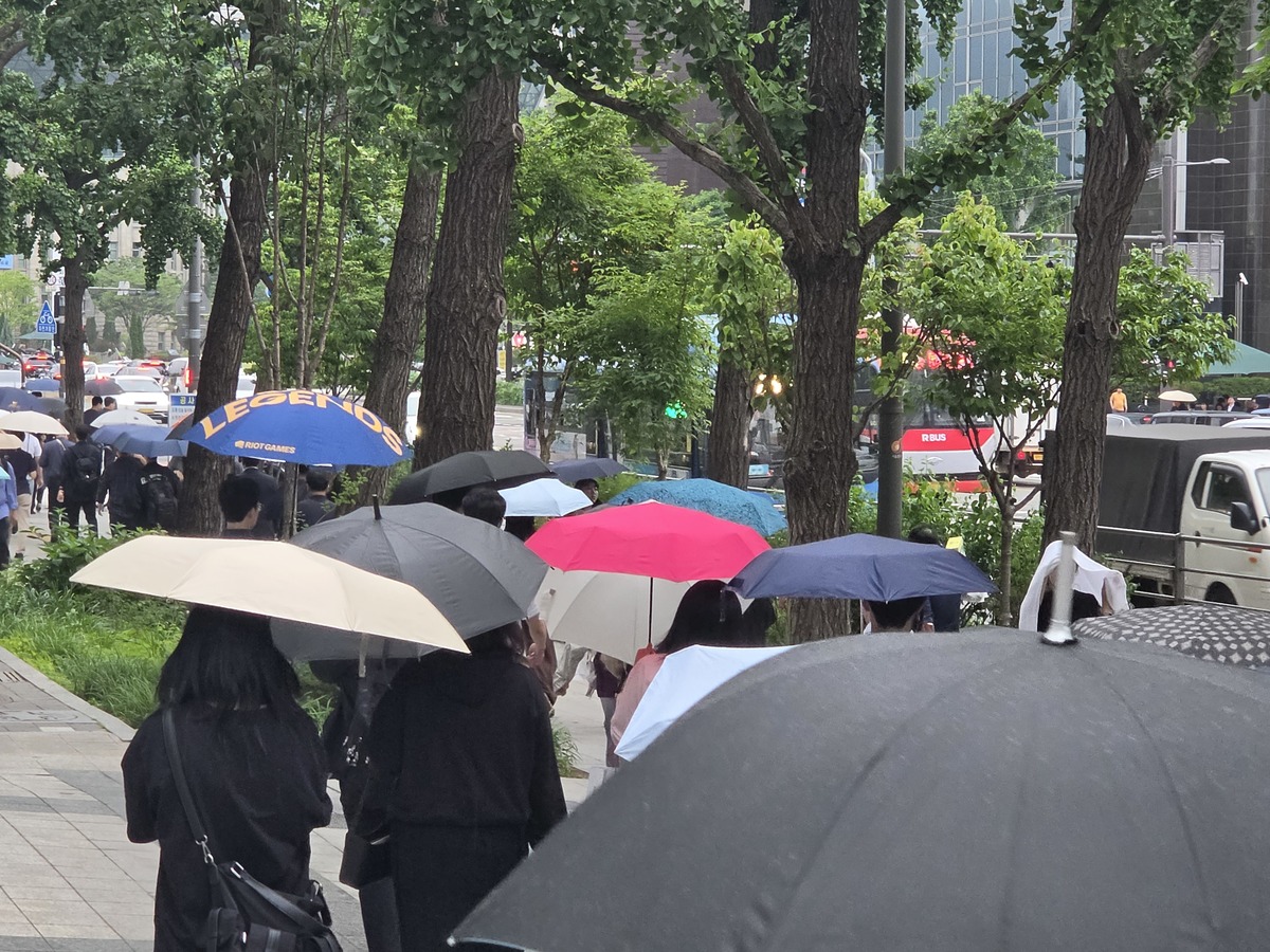 27일 오후 서울 중구 서울시청 인근에서 시민들이 비를 피해 우산을 쓰고 있다. 뉴스1