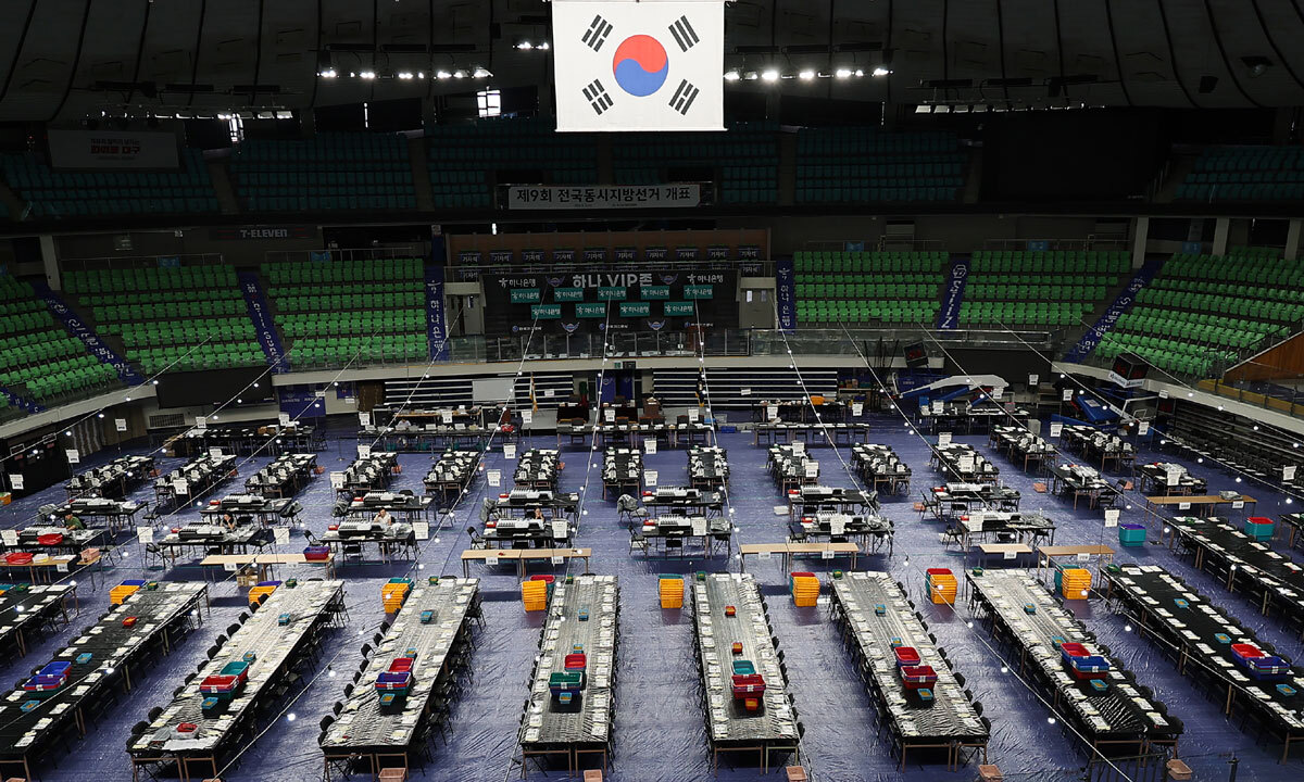 6·3 지방선거를 이틀 앞둔 1일 대구 북구 대구체육관에 설치된 개표소에서 선관위 관계자들이 막바지 점검 중인 가운데 태극기 뒷면이 보이고 있다. 연합뉴스