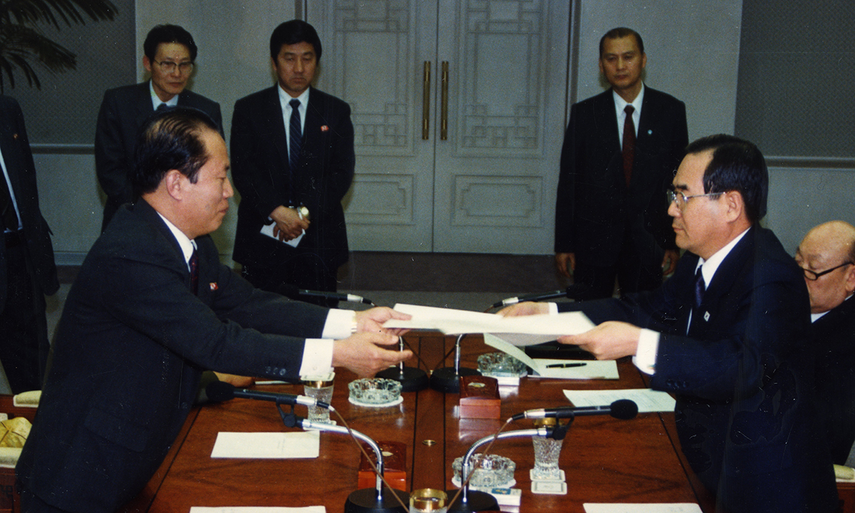 1992년 3월14일 판문점 남측 지역 ‘평화의 집’에서 열린 남북핵통제공동위원회 구성·운영을 위한 제7차 대표접촉에서 최우진 북한 대표(왼쪽)가 임동원 남한 대표에게 문서를 전달하고 있다. 통일부 제공