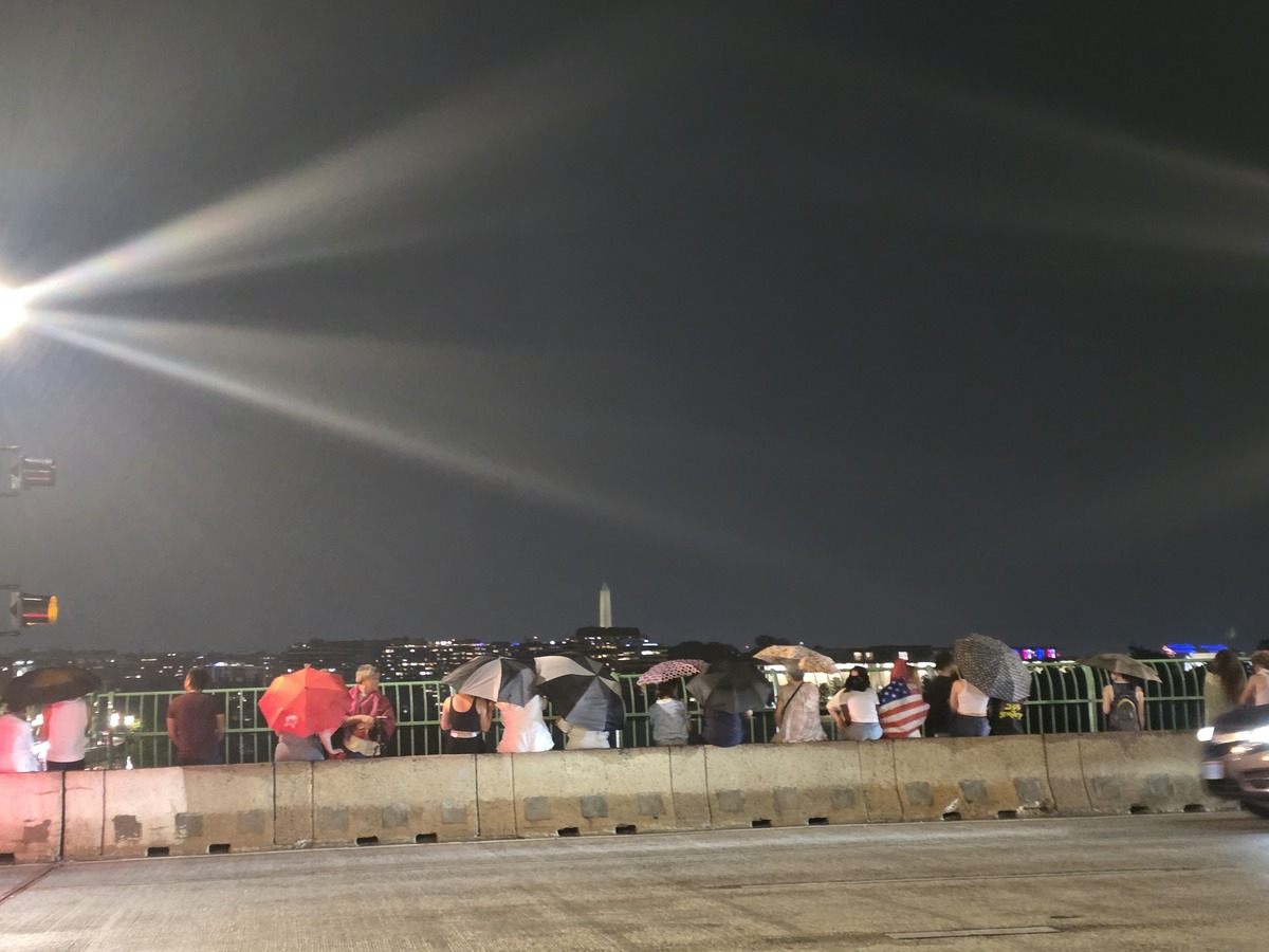 4일(현지시간) 독립기념일 불꽃놀이를 기다리던 중 비가&nbsp;쏟아지자 시민들이 우산을 꺼내들고 있다. 워싱턴=홍주형 특파원