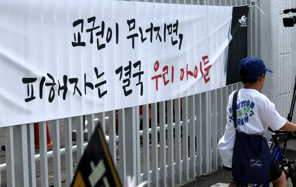 전국교사일동 소속 회원들이 서이초등학교 교사 순직 3주기를 하루 앞둔 17일 서울 종로구 정부서울청사 인근에서 교권보장을 위한 아동복지법 즉각 개정을 요구하는 집회를 하고 있다. 청사 울타리에 "교권이 무너지면 피해자는 결국 우리 아이들"이라고 적힌 플래카드가 걸려 있다.