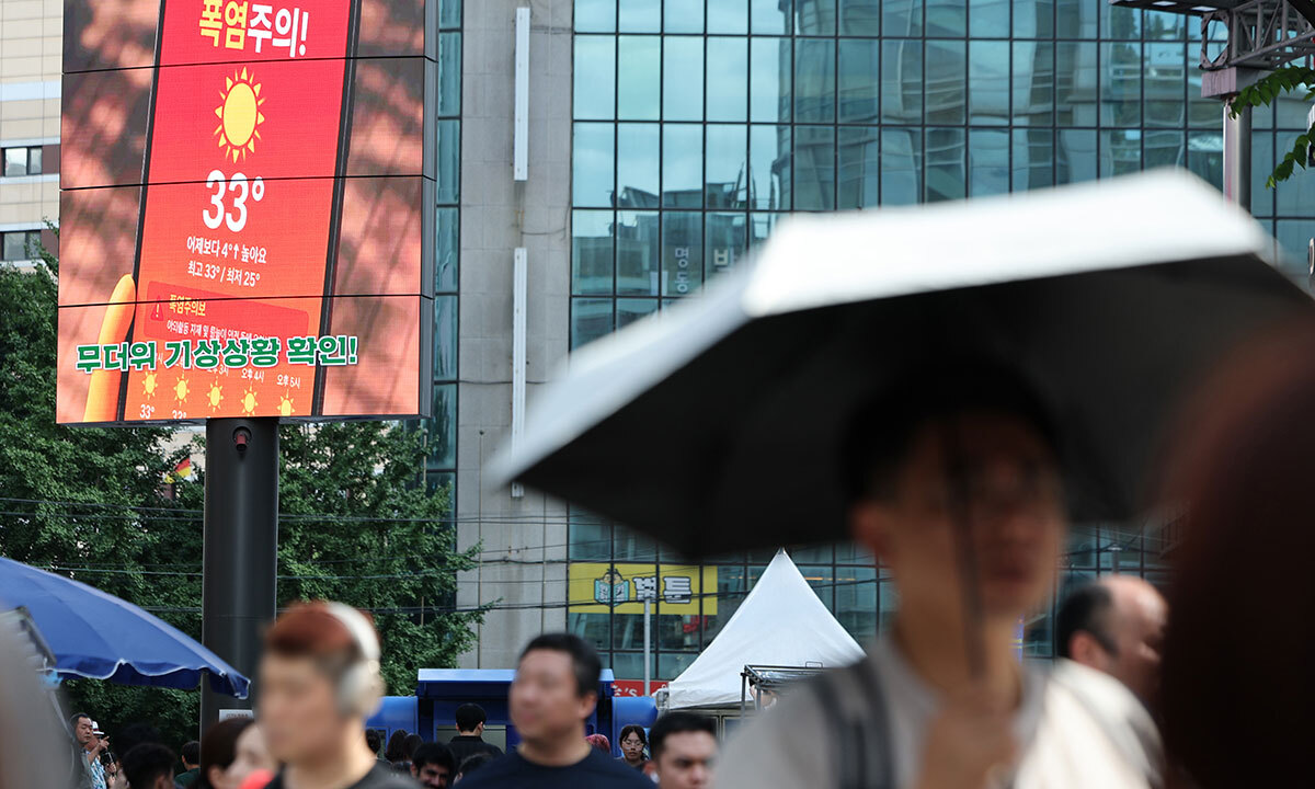 서울 전역에 폭염주의보가 발효된 26일 서울 명동 거리의 한 전광판에 폭염 주의 안내문이 나오고 있다. 연합뉴스