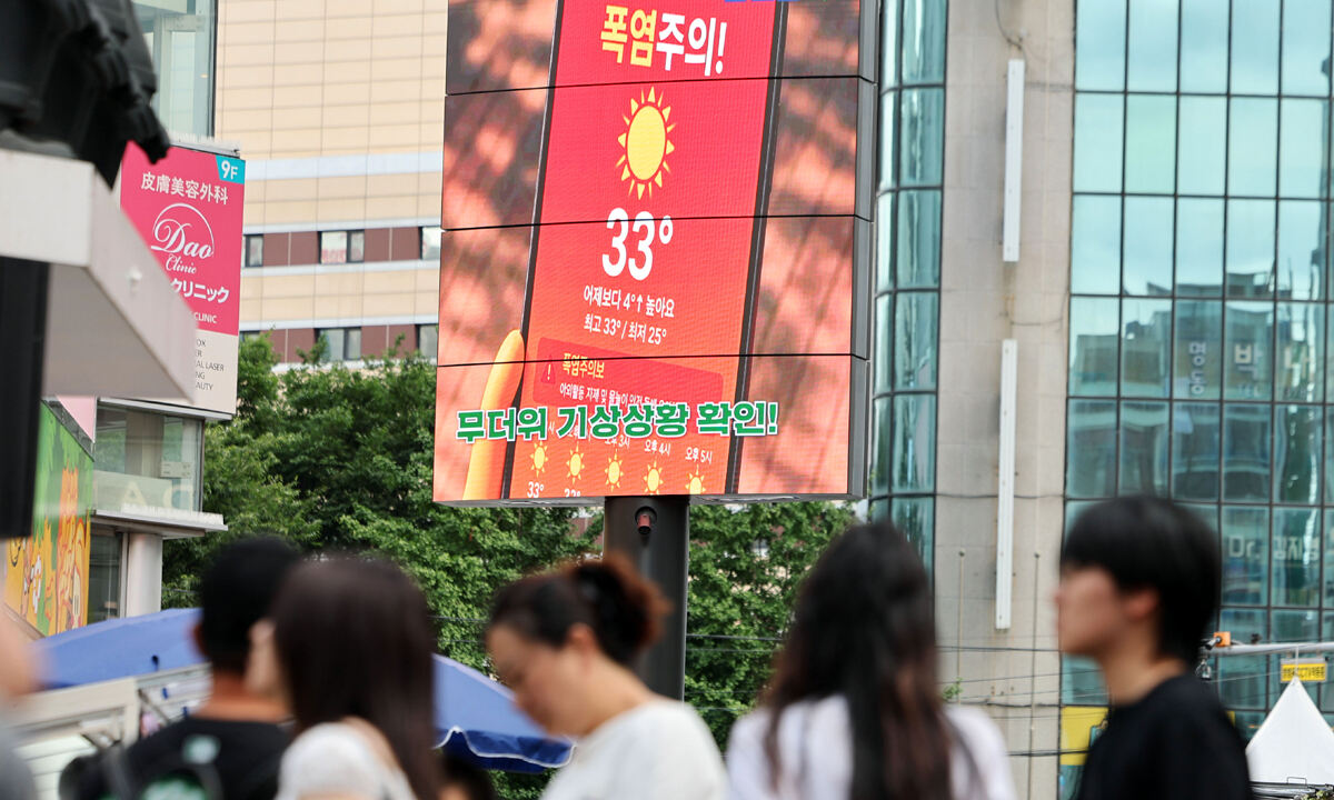 서울 전역에 폭염주의보가 발효된 26일 서울 명동 거리의 한 전광판에 폭염 주의 안내문이 나오고 있다. 연합뉴스