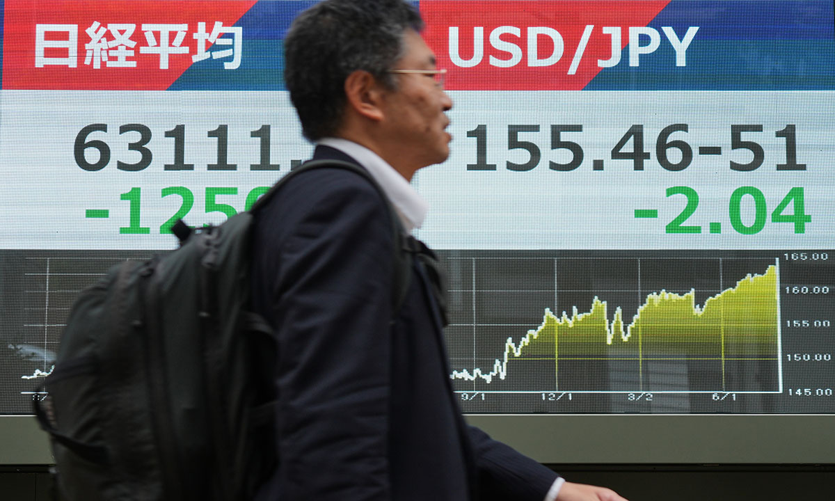 3일 월요일 도쿄의 한 증권사에서 한 사람이 일본 닛케이 지수와 미 달러-엔 환율을 보여주는 전광판 앞을 지나가고 있다. AP연합뉴스