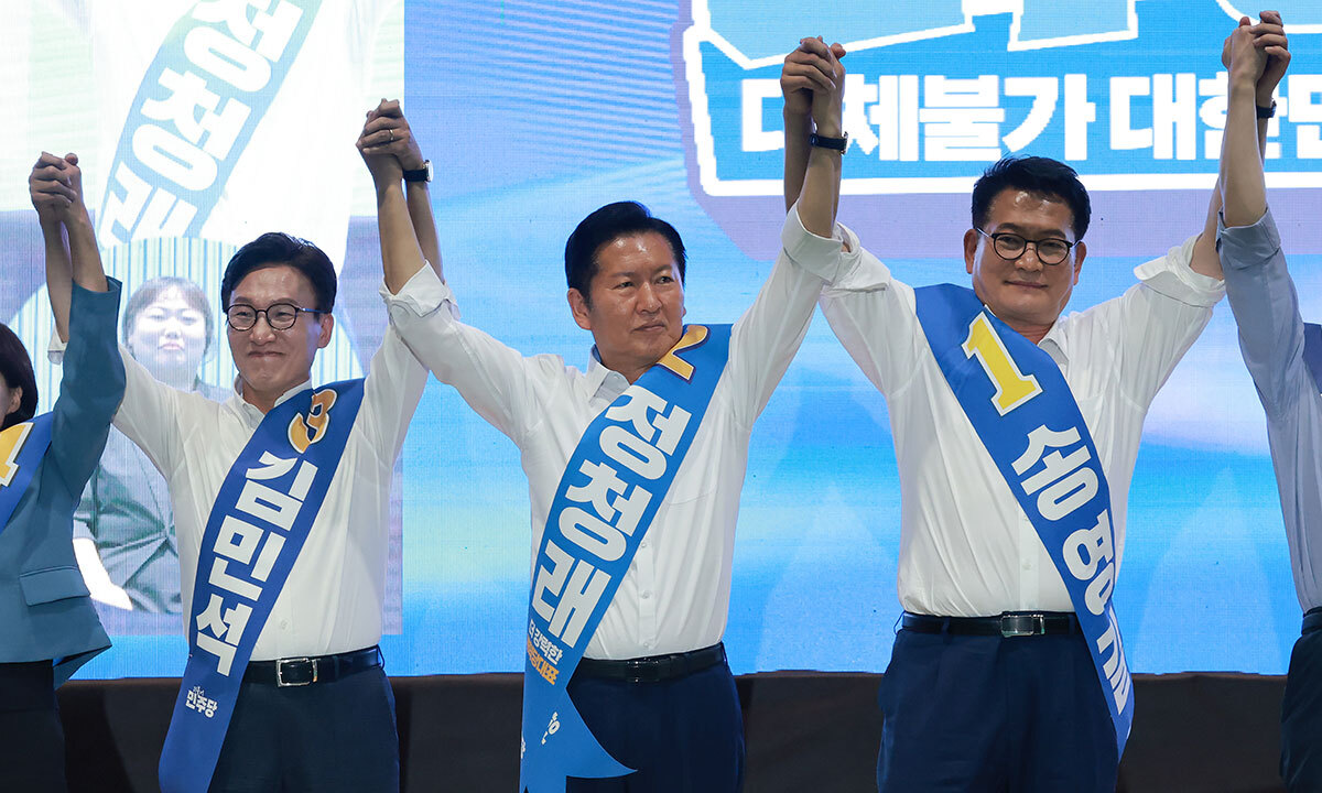 강원 합동연설 더불어민주당 당대표 경선 주자인 김민석(왼쪽부터)·정청래·송영길 후보가 9일 강원 횡성국민체육센터에서 열린 민주당 대표·최고위원 후보자 강원 합동연설회에서 손을 맞잡고 머리 위로 들어 올리고 있다. 횡성=연합뉴스