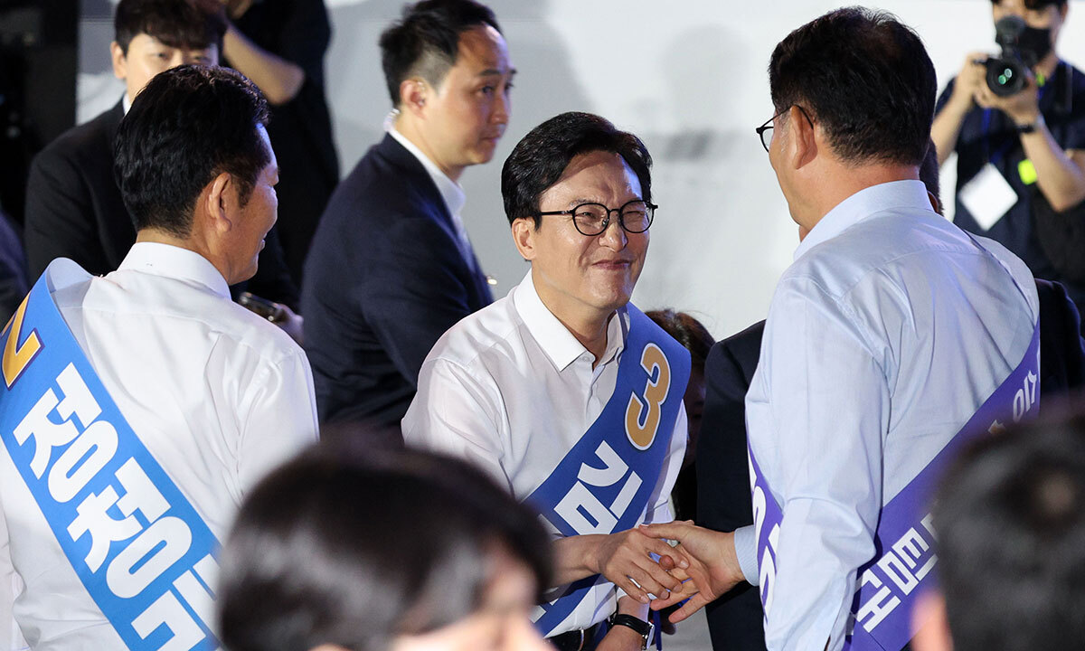 김민석 더불어민주당 당대표 후보가 16일 경기 고양시 일산서구 킨텍스 제2전시장에서 열린 민주당 당대표·최고위원 후보자 서울 합동연설회에서 정견발표를 마치고 정청래, 송영길 후보와 악수하고 있다. 뉴시스