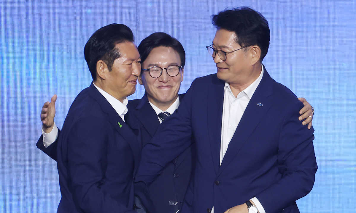 더불어민주당 당 대표에 출마한 김민석 전 총리가 17일 대전 컨벤션센터에서 열린 제3회 더불어민주당 정기 전국당원대회에서 당 대표 당선을 확정한 뒤 본선에서 경쟁을 벌였던 정청래 전 대표, 송영길 의원과 포옹하고 있다. 연합뉴스