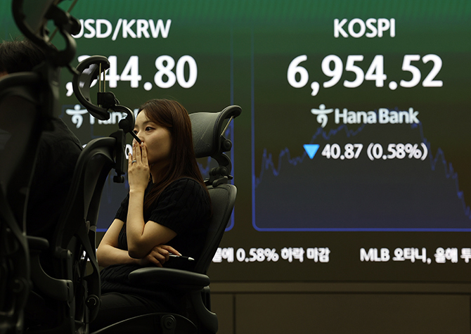 코스피가 전 거래일 대비 40.87포인트(0.58%) 내린 6954.52로 마감한 8일 서울 하나은행 본점 딜링룸에서 딜러들이 업무를 보고 있다. 연합뉴스