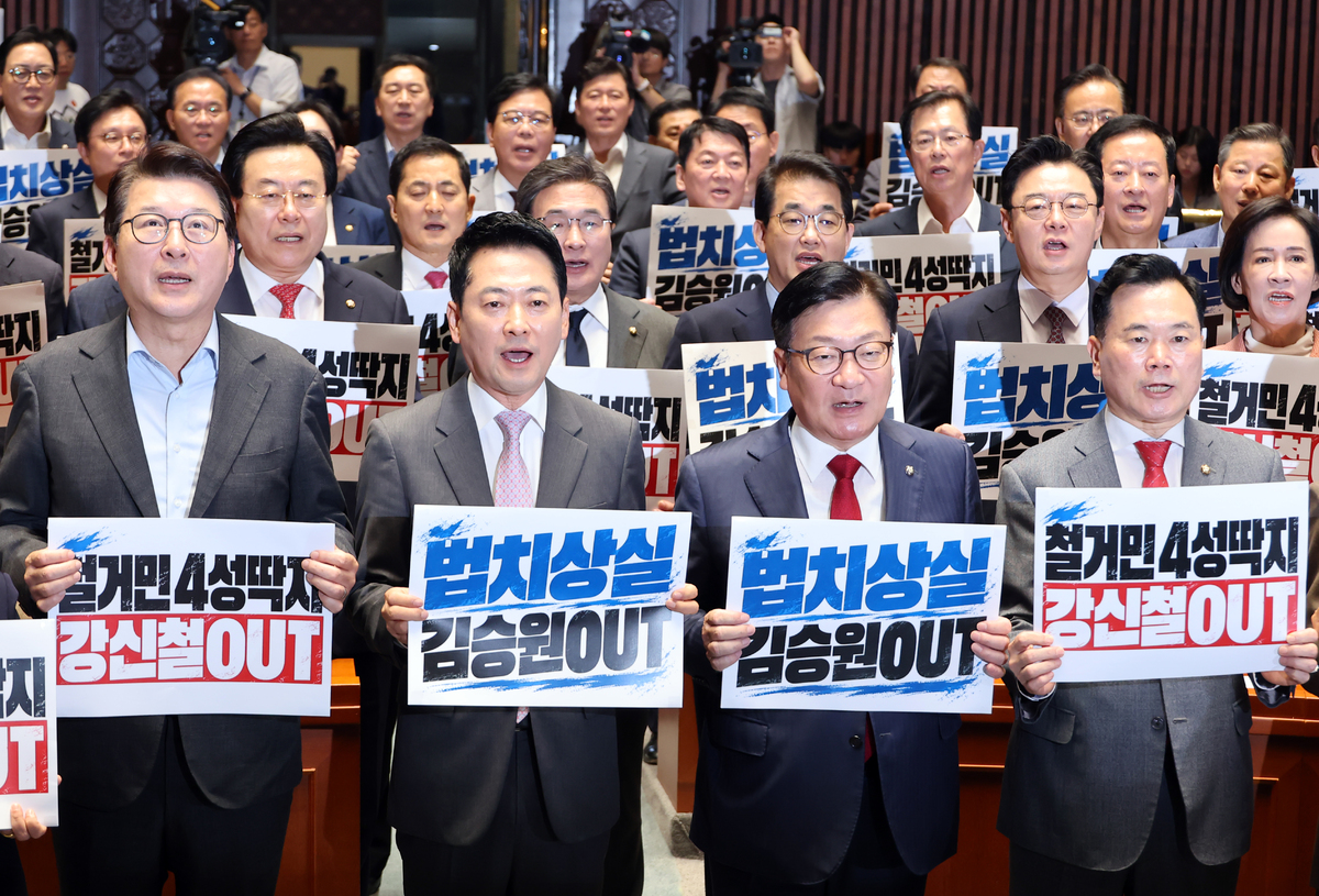 국민의힘 장동혁 대표와 정점식 원내대표를 비롯한 의원들이 17일 국회에서 열린 의원총회에서 '철거민 4성딱지 강신철 OUT', '법치상실 김승원 OUT' 피켓을 들고 구호를 외치고 있다. 연합
