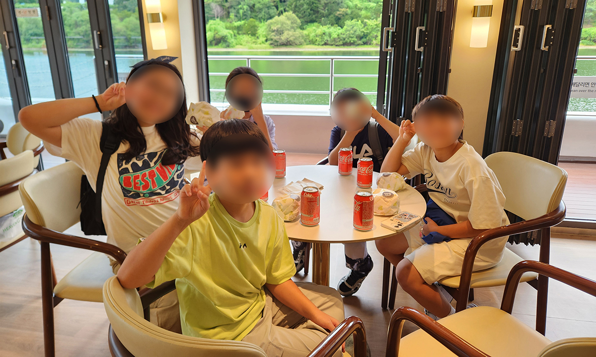 체험에 참여한 아동들이 북한강을 운항하는 가평크루즈 선내에서 식사를 즐기고 있다.