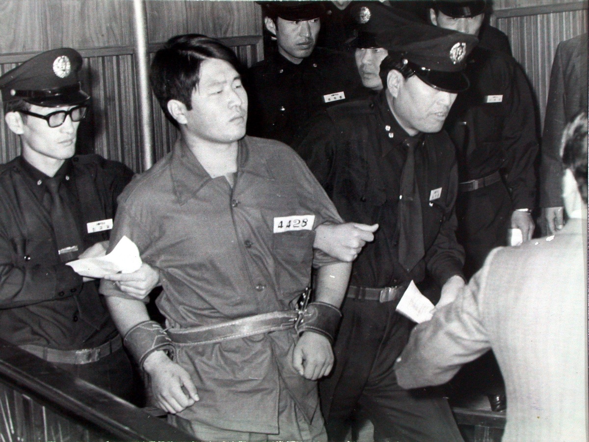 1974년 육영수 여사 저격 사건 진범인&nbsp;문세광이 교도관들에 의해 호송되고 있다. 그는 법정에서&nbsp;“나는 육 여사를 겨냥하지 않았다”고 진술해 원래 목적은 박정희 대통령이었음을 내비쳤다. 세계일보 자료사진
