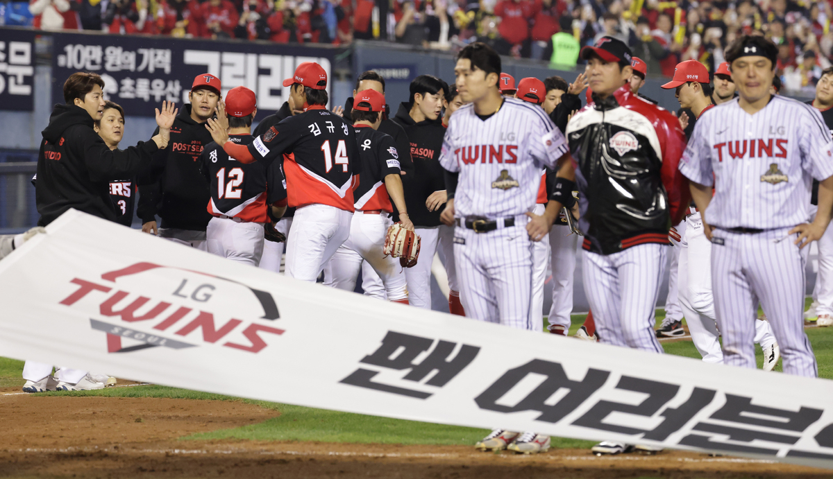 KIA 타이거즈 선수들이 20일 서울 잠실야구장에서 열린 LG 트윈스와의 KBO 프로야구 포스트시즌 준플레이오프 3차전에서 13-1로 승리하며 플레이오프 진출을 확정한 뒤 기뻐하고 있다. 그 앞으로는 LG 선수들이 아쉬워하고 있다. 연합뉴스